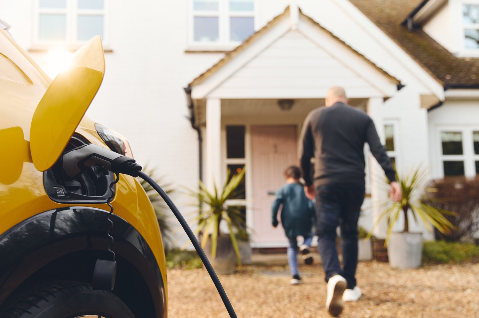 Electric car charging on driveway outside home with