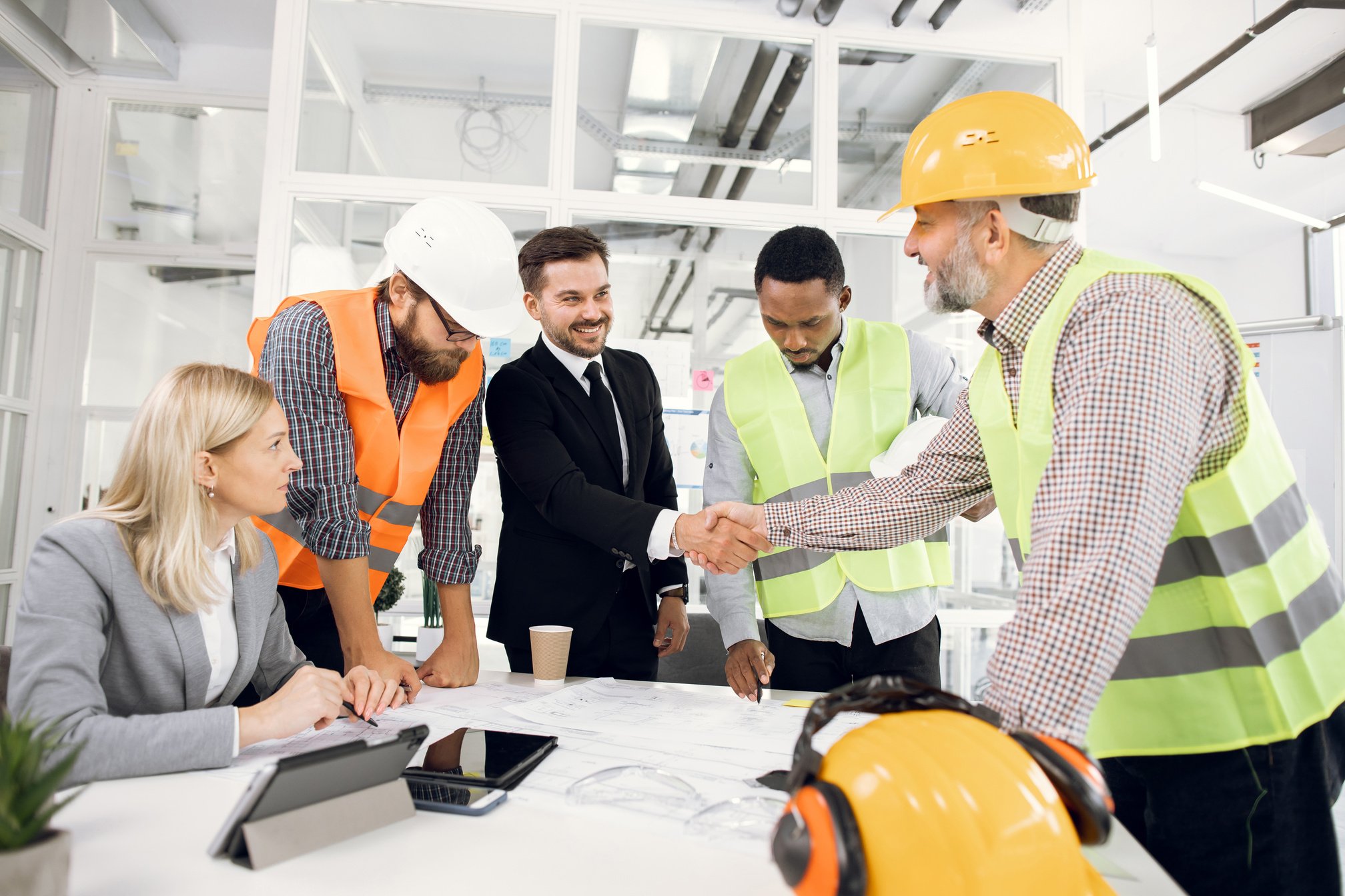 Happy construction team shaking hands during conference